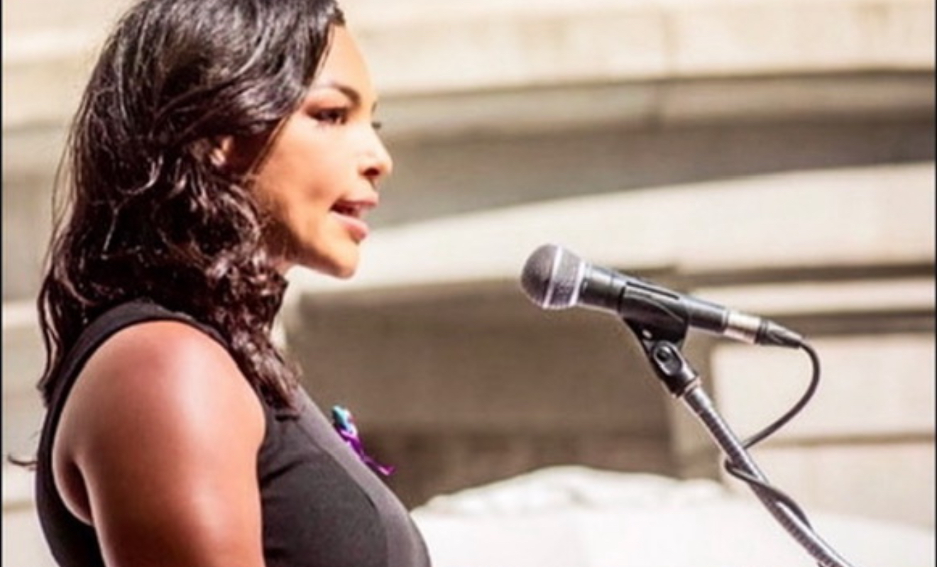 Jamie speaking at outdoor podium, side profile